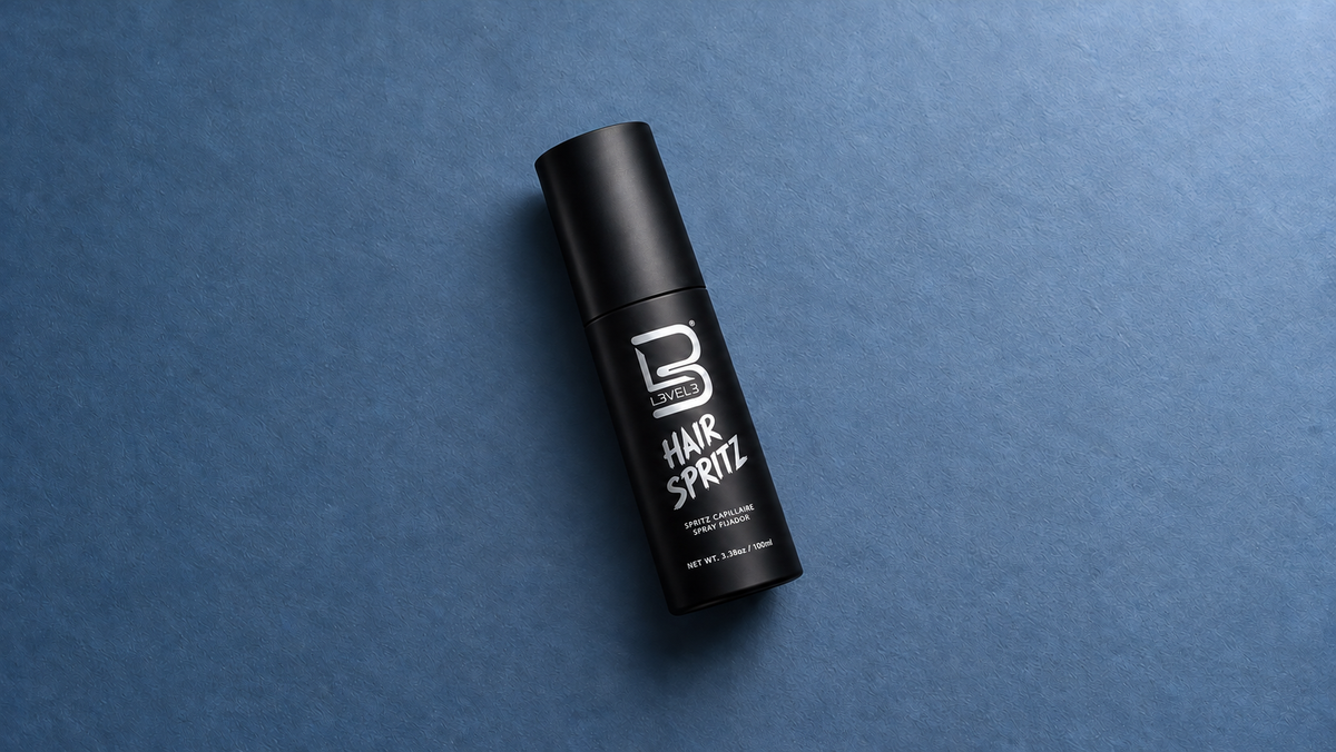 L3VEL3 Hair Spritz bottle angled in a spacious slate-blue landscape composition