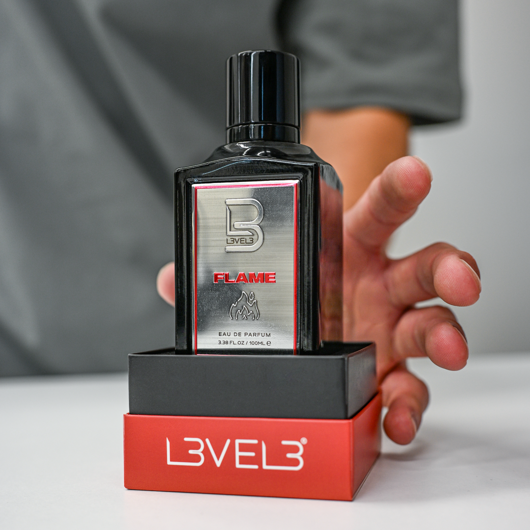 Perfume bottle with 'Level 3' packaging held by a person against a neutral background