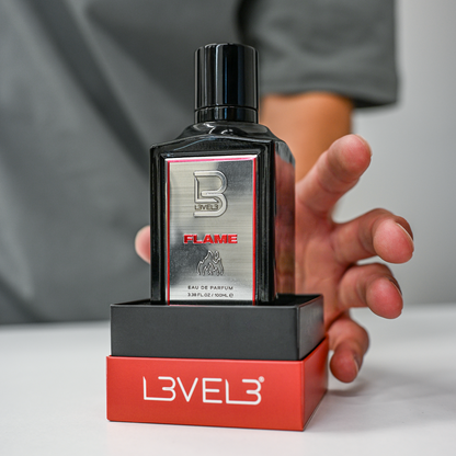 Perfume bottle with 'Level 3' packaging held by a person against a neutral background
