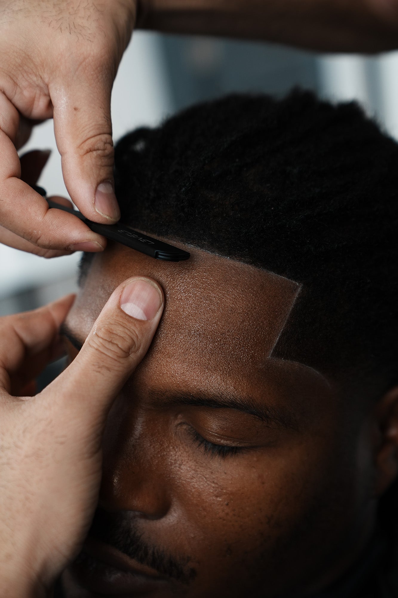 Person getting a haircut with close-up of hands and hair.