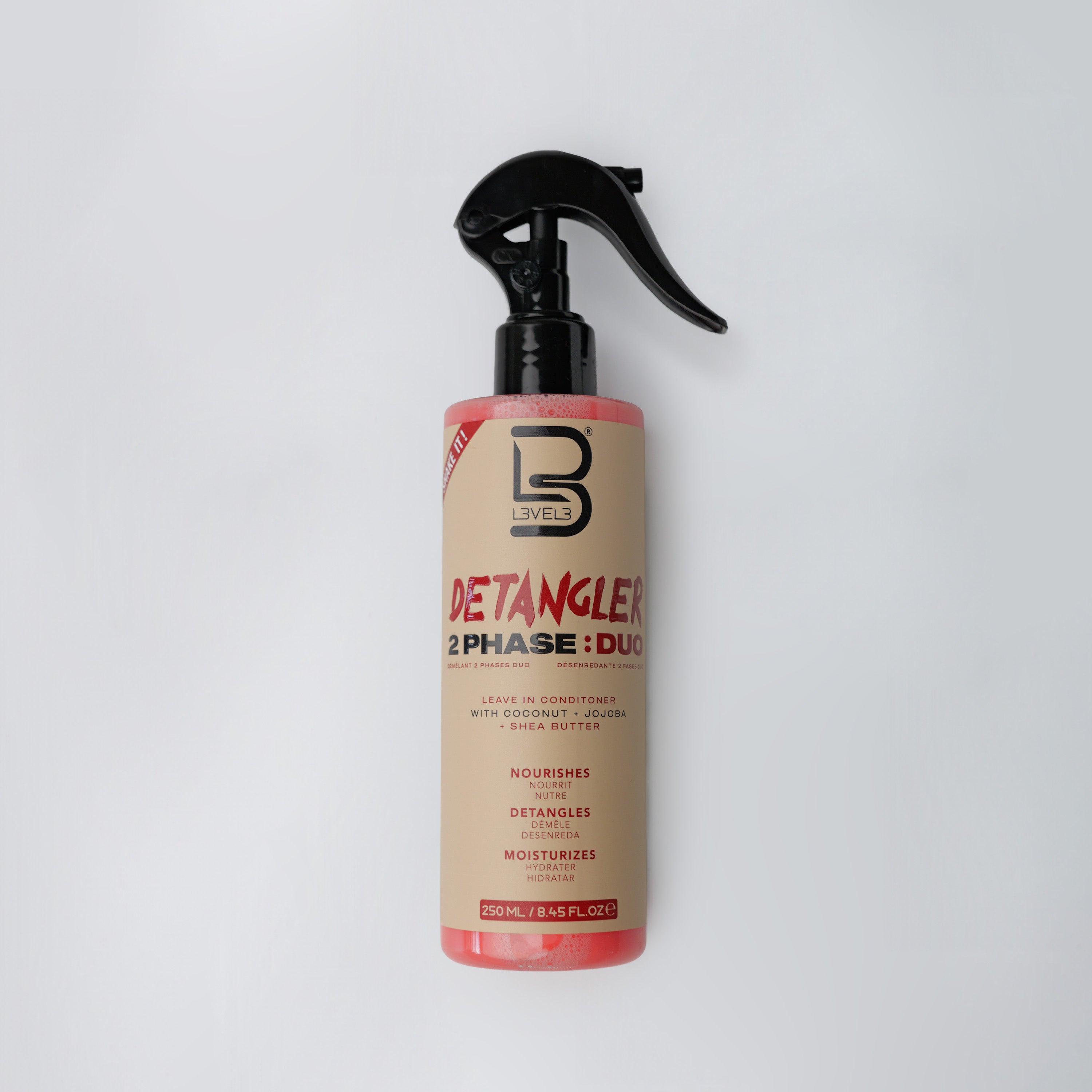 Detangler spray bottle with black nozzle on a white background