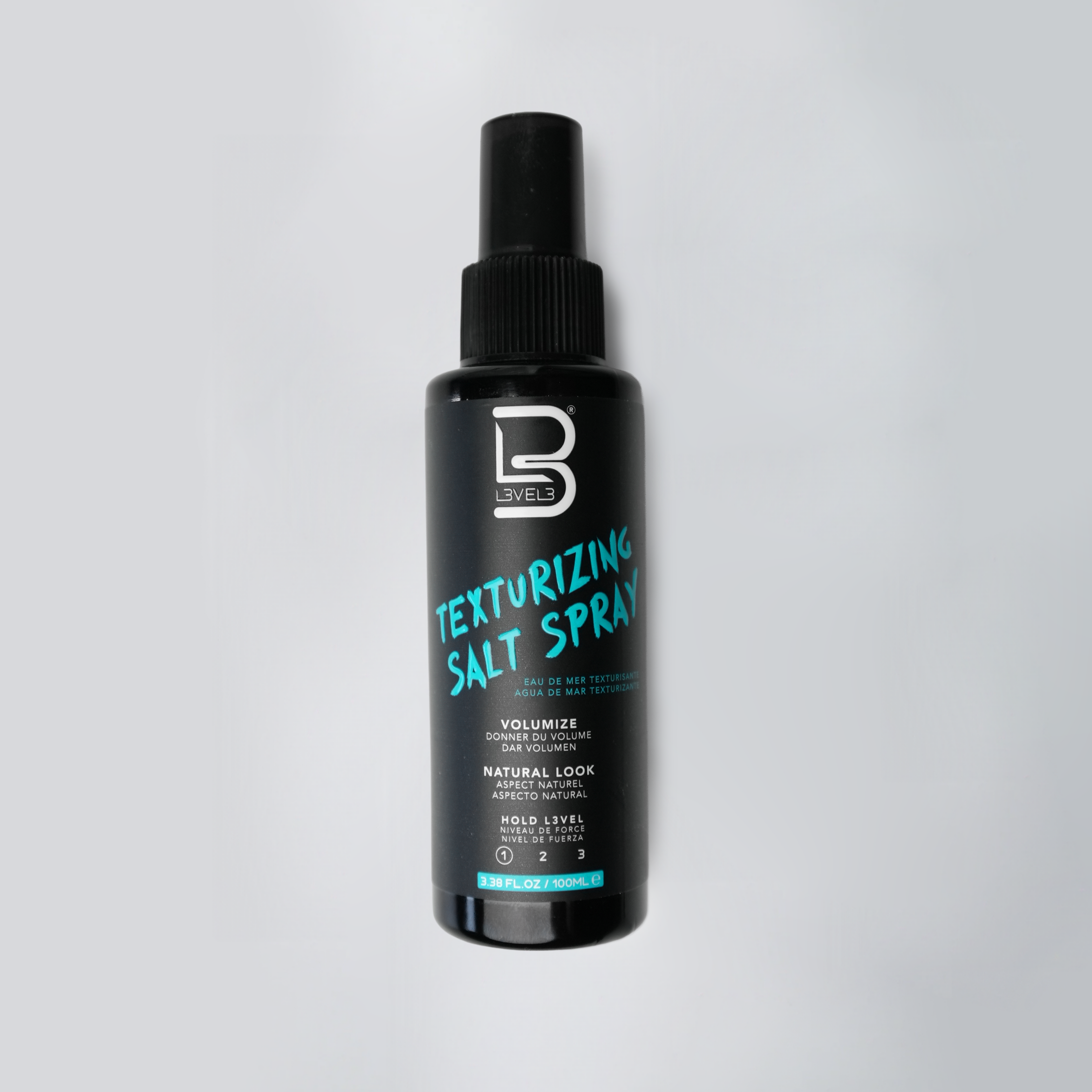 Texturizing salt spray bottle with black label on a light gray background